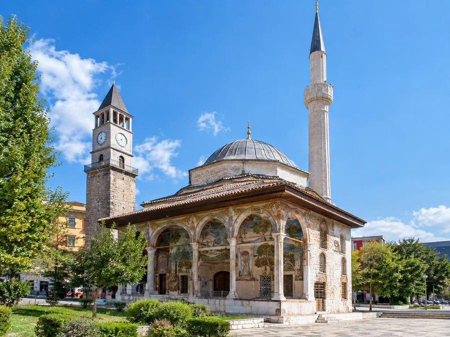 The Et'hem Bey Mosque with its painted portico and slim minaret, the Clock Tower behind