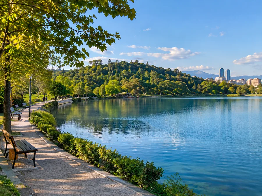 The artificial lake in Tirana's Grand Park, ringed by green wooded hills